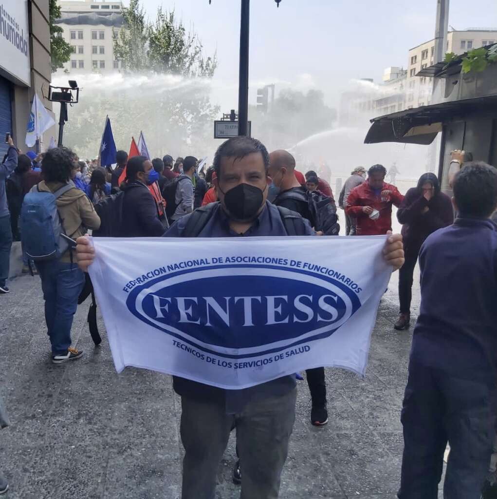 Freddy Sepúlveda Presidente FENTESS mojado por carros lanza aguas de Carabineros.